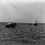 Charlie Mac driving through sea tide off the ferry courtesy NPS Collection